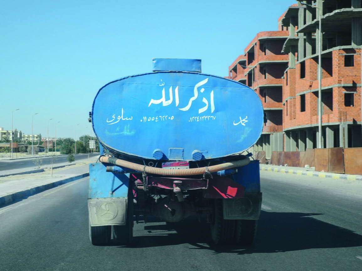 a truck on the road with word inscription on the back 