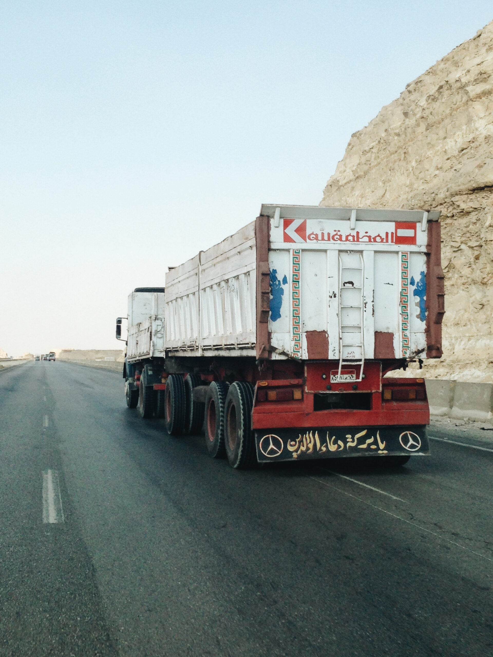 a truck on the road with word inscription on the back 